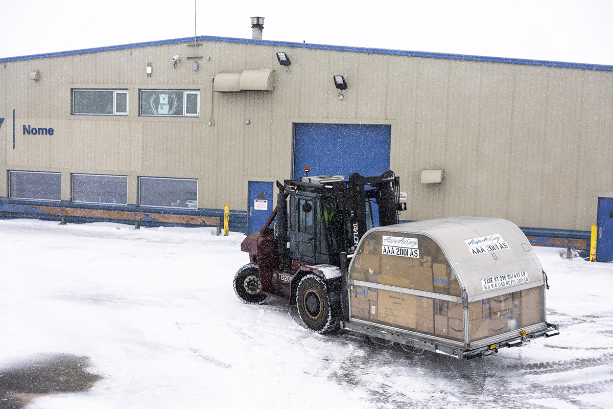Forklift with cargo container in the snow in Nome.