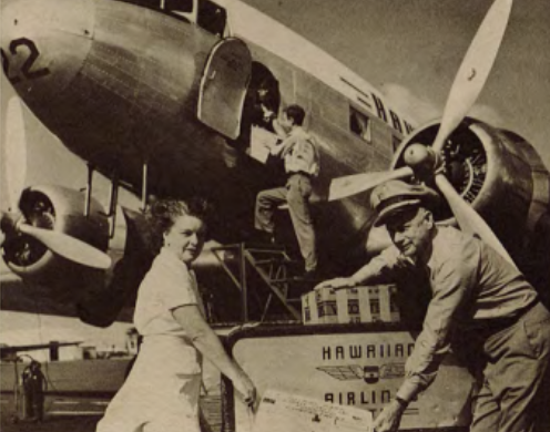 Historic photo showing a man and a woman carrying a box labeled Hawaiian Airlines
